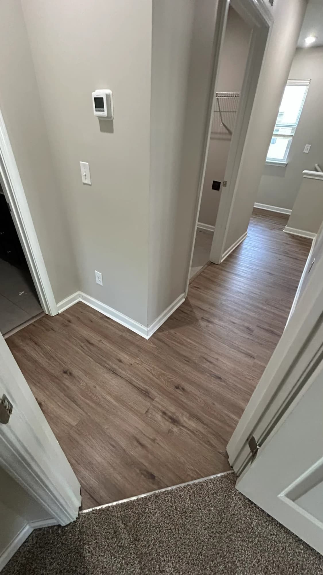 Warm oak luxury vinyl plank running cleanly down a hallway and into several rooms in a Charlotte home