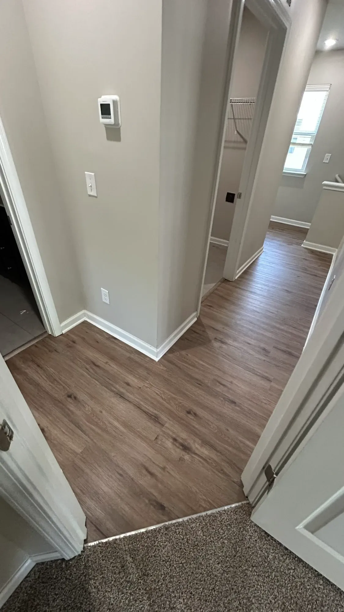Warm oak luxury vinyl plank running cleanly down a hallway and into several rooms in a Charlotte home